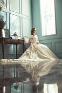 Woman in the white wedding dress on the chair