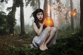 beautiful woman in the foggy forest with light container