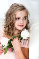 girl with curly hair and a white rose