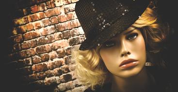 handsome mannequin in hat on brick wall background