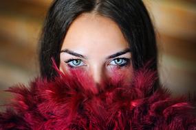 girl's face is hidden behind burgundy feathers