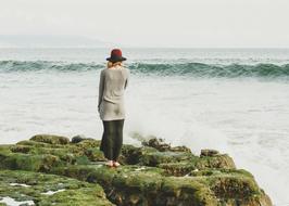 back view of Woman on rock looking at Ocean