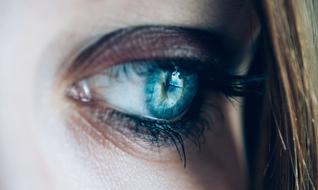 Closeup photo of a blue female eye with long eyelashes