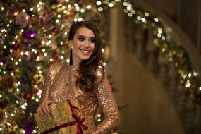 Girl in golden dress wit Gift in hands