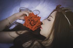 Girl Sleeps with red rose at face