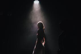 girl in the dark under the spotlight