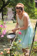 young Woman watering flowers in garden