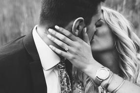 Black and white photo of the bride and groom kissing