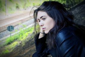 photo of a tired girl in a black jacket