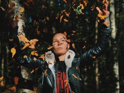 girl in a leather jacket in yellow leaves