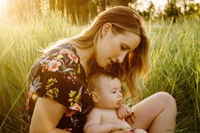 mom with baby on green grass