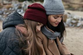 Portrait of the mom and daughter with red and grey hats