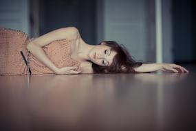 Beautiful Woman lays on floor with close eyes