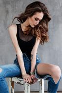 stylish young woman sitting and posing on the white chair