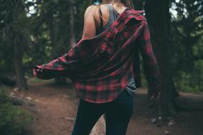 Back view of Female Person in casual clothing at forest