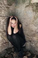 frightened young girl at old stone wall