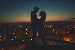 silhouette of a couple in love on the background of a night city