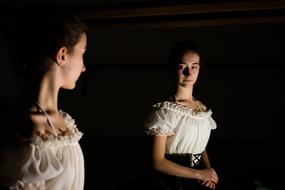 young girl looking at Mirror in darkness