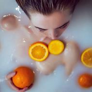 model taking bath with oranges