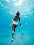 girl in a white swimsuit under the ocean