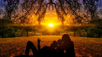 silhouette of a family at colorful sunset on horizon