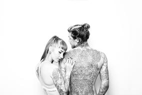 tattoos on the body of a young couple, back view