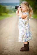 Photographer, nice caucasian child girl Taking Picture outdoor
