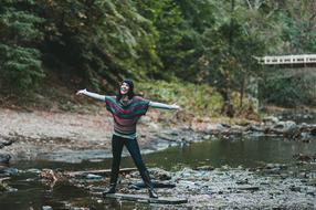 woman with open arms in the middle of the river