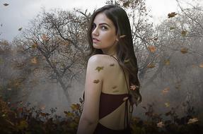 girl in a light dress on a background of colorful leaf fall