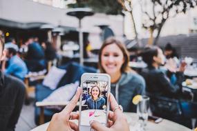 taking pictures of a girl on a smartphone with a blurred background