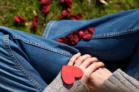 woman's legs, red heart and rose petals