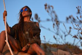 model in sunglasses with wood stick