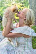 Happy Woman kissing Puppy dog outdoor