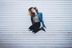 girls jump on a background of a wooden wall