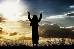 Woman Praying Believing at sunset