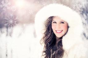 photo of a girl in a white fur hood under a snowfall
