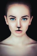 Portrait of the beautiful girl, with the kitten make-up and blue eyes, in light, at black background