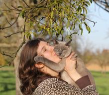 Portrait of Young Woman kissing Cat outdoor