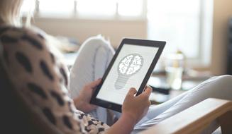 Blonde woman, using tablet, with the idea image, while sitting