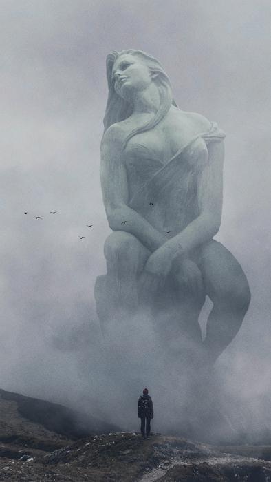 fantastic photo of a female sculpture in the fog in the mountains