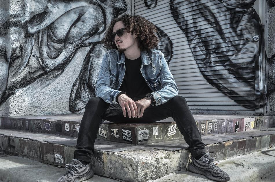 young stylish man near black and white graffiti