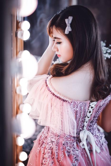 Back view of the Japanese girl, in the colorful and beautiful dress, near the lights