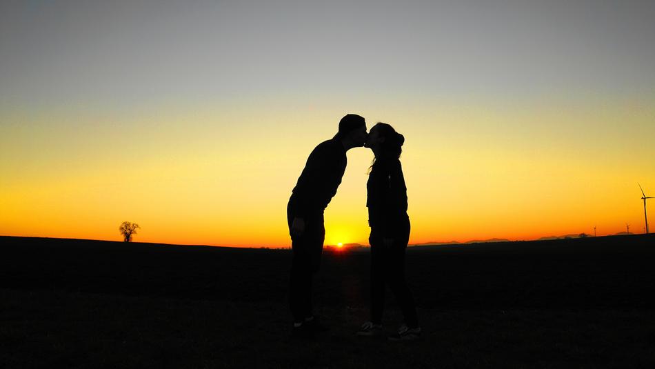 silhouette of a kissing couple in the evening