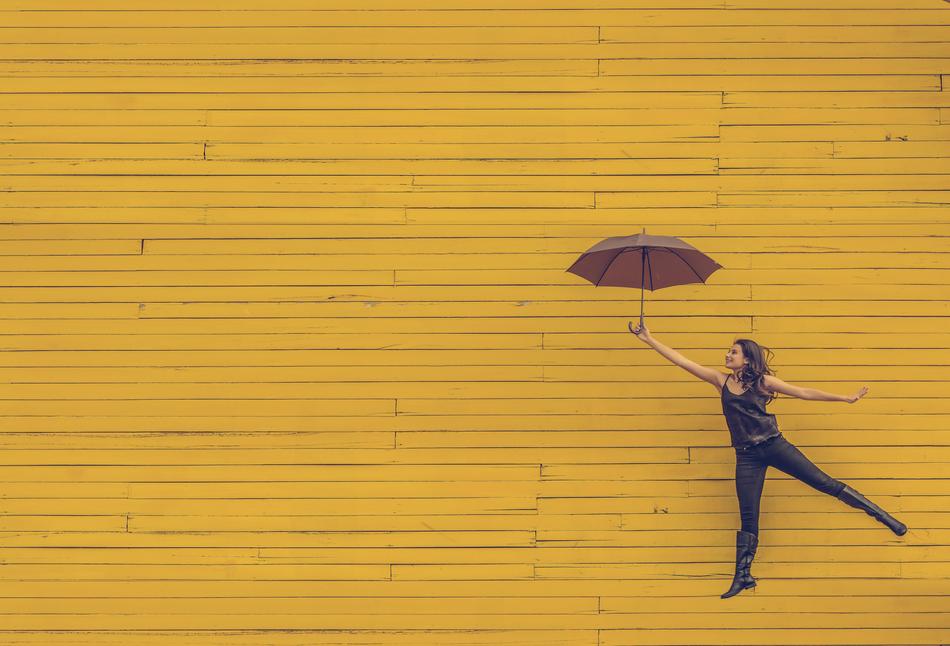 girl with umbrella on yellow wooden background