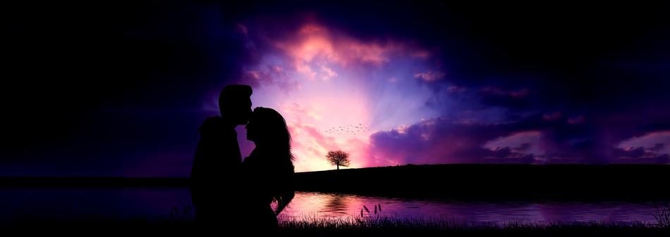 silhouette of a couple in love on the lake at dusk