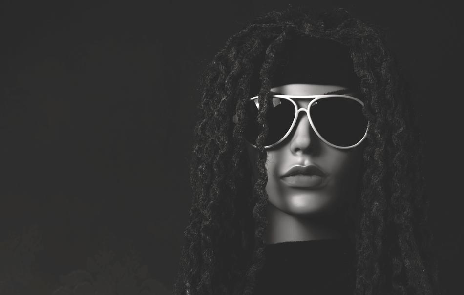 Black and white portrait of the woman with glasses on dark background