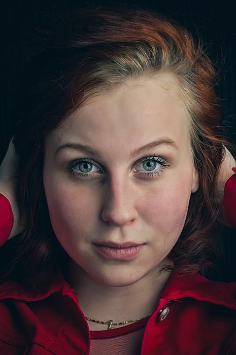 Portrait of the girl with blue eyes and red cheeks, in red shirt, with necklace