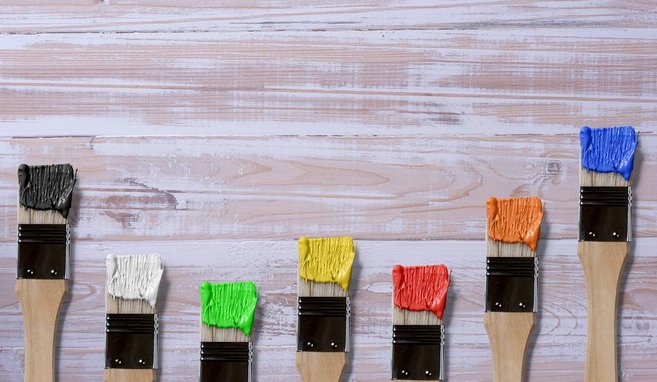 Brushes covered with paint on wooden surface
