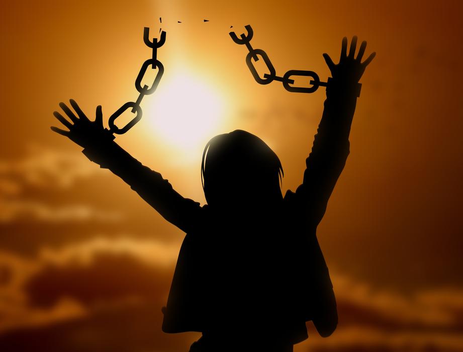 freedom, silhouette of woman with broken chain on hands at sunset sky