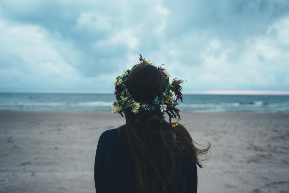 girl in a wreath on the beach in a storm